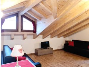 un soggiorno con soffitti in legno e una TV di Chalet Selva a Valdidentro