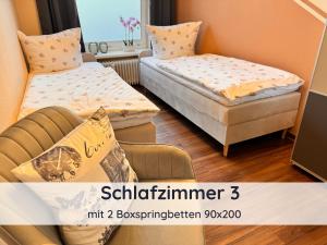 a room with two beds and a chair in it at Ferienwohnung Auszeit Harz in Bad Sachsa