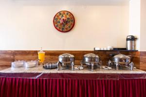 a table with pots and pans on top of it at Treebo Hotel Mobi VIP Airport in Guwahati