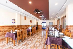 a restaurant with wooden floors and tables and chairs at Treebo Hotel Mobi VIP Airport in Guwahati