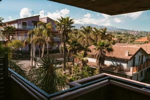 a view from the balcony of a house with palm trees at Orchidea Catania in San Giovanni la Punta