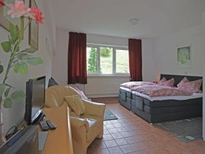 a bedroom with a bed and a couch and a tv at Apartment in Lennestadt for 2 Person in Lennestadt +63 photos