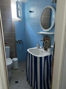 a blue bathroom with a sink and a mirror at Sufiko Studios - Thea in Armenistis
