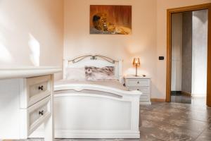 a bedroom with a white bed and a picture of a lion at Orchidea Catania in San Giovanni la Punta