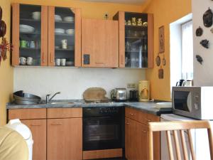 a kitchen with wooden cabinets and a stove top oven at Apartment in Lennestadt for 2 Person in Lennestadt