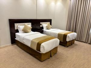 zwei Betten in einem Hotelzimmer in der Unterkunft راجان للشقق المخدومة in Ta'if + 55 Fotos