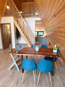 a dining room with a wooden table and blue chairs at Transylvantures Cabin in Rimetea +17 photos