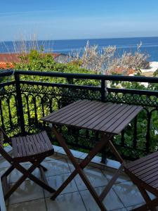 a picnic table and two chairs on a balcony with the ocean at Sufiko Studios - Thea in Armenistis
