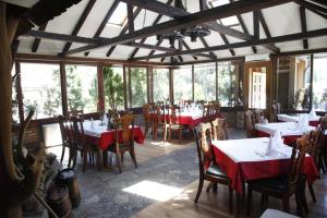 a dining room with tables and chairs and windows at Motel Restoran DURMITOR in Nikoljac