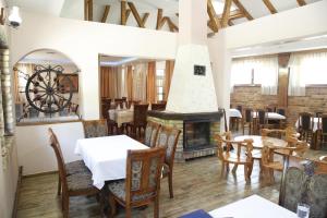 a restaurant with a fireplace and tables and chairs at Motel Restoran DURMITOR in Nikoljac