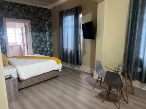 a bedroom with a bed and a table and a television at Peaceful Accommodation in Durban