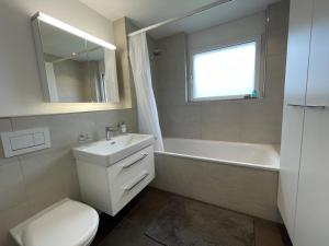 a bathroom with a sink and a tub and a toilet at Brüttisellen, Lindenbuck in Brüttisellen