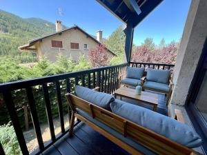 a balcony with a couch and chairs on a deck at Triplex 8 people 4 bedrooms in Saint-Chaffrey