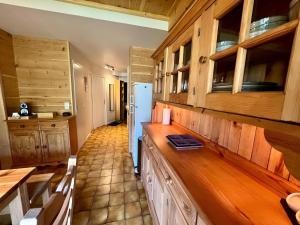 a kitchen with wooden cabinets and a counter top at Triplex 8 people 4 bedrooms in Saint-Chaffrey