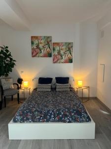 a bedroom with a bed with two paintings on the wall at Appartement privé « Rive Droite » in Serrières