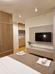 a bedroom with a television and two towels on a bed at Luxury Apartments Stefano - Premium in Ohrid