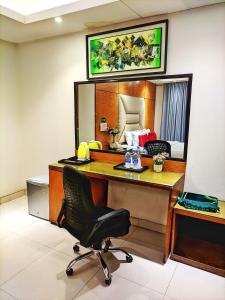 a desk with a chair and a mirror in a room at Hotel Afford Inn in Dhaka