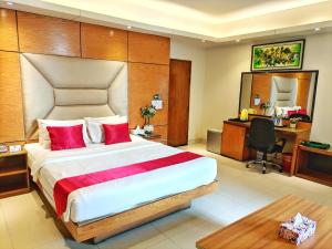 a bedroom with a large bed with a desk and a computer at Hotel Afford Inn in Dhaka +33 photos