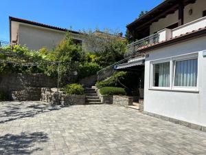 a house with a brick driveway next to a building at Apartma Eva in Portorož