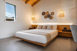 a bedroom with a large bed and a window at Calarè Boutique Rooms - Adults Only in Cala Sinzias +17 photos