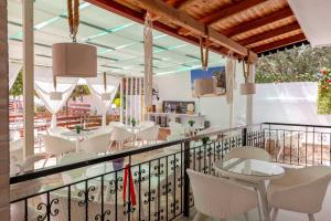a restaurant with white chairs and tables on a balcony at Ksamil Guesthouse Villa in Ksamil