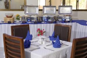 a table with blue napkins on it with two monitors at The Avid Hotel in Voi