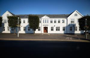 a large white building with a red door at Westergaards Hotel in Videbæk