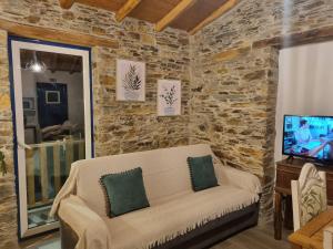 a living room with a couch and a tv at Casa da Eira in Arganil