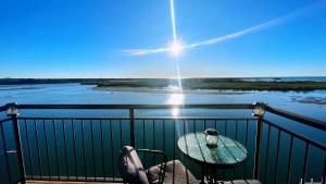 a table on a balcony with a view of the water at Banyandah Towers in Maroochydore