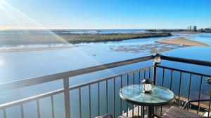 a balcony with a table and a view of the water at Banyandah Towers in Maroochydore