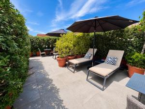 a patio with two chairs and an umbrella at Venetian Palace Chania - Adults Only in Chania