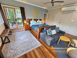 a bedroom with a bed and a couch at Cosy Studio with Forest Views, Noosa Hinterland in Doonan