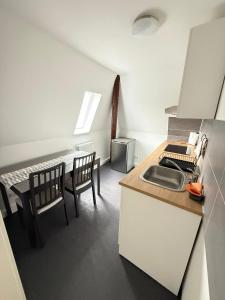 a kitchen with a sink and a table with chairs at Gästehaus E&E in Nierstein