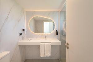 a bathroom with a sink and a mirror at Olive Beach Apartamentos in Port d'Alcudia +39 photos