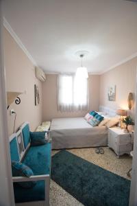 a small bedroom with a bed and a couch at Apartment Corinth in Korinthos