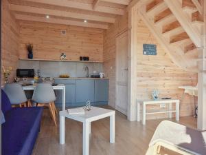 a kitchen and living room in a wooden cabin at Baltic Domki Sarbinowo in Sarbinowo +9 photos