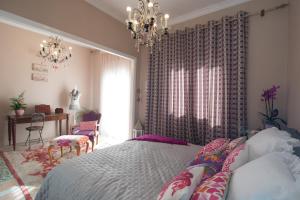 a bedroom with a bed and a chandelier at Apartment Corinth in Korinthos