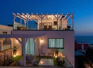 a house with a view of the ocean at night at VILLA HELENA Amber Apartment in Caniço