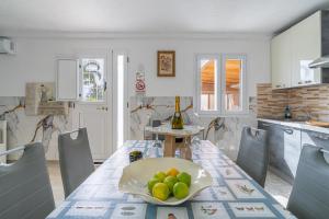 a kitchen with a table with a bowl of fruit on it at Jungle Holiday Villa in Avola