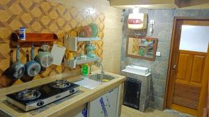 a kitchen with a sink and a stove in it at Mulia Home Stay in Nusa Dua