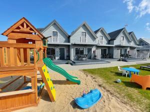 a playground in front of a house at Baltic Domki Sarbinowo in Sarbinowo