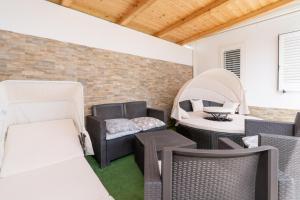 an outdoor patio with wicker chairs and a table at Jungle Holiday Villa in Avola +21 photos