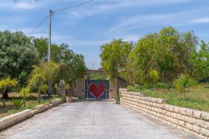 a gate with a red heart painted on it at Jungle Holiday Villa in Avola