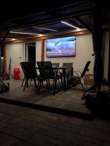 a table and chairs in a room with a projection screen at Time to Relax in Zalakaros