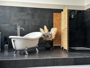 a bath tub in a bathroom with black tiles at Ro42om Schönewerd in Schönenwerd