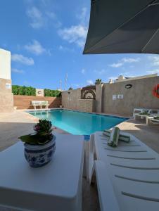 a patio with a table and a swimming pool at Ta Robert Farmhouse in San Lawrenz