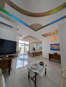 a living room with a flat screen tv and a table at Ta Robert Farmhouse in San Lawrenz