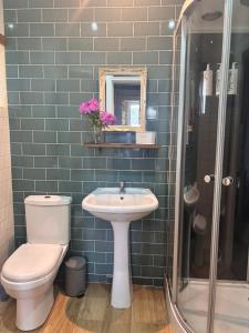 a blue tiled bathroom with a toilet and a sink at La Ramée - 2 bedroom - Wi-Fi - Garden - Parking in Saint-Siméon