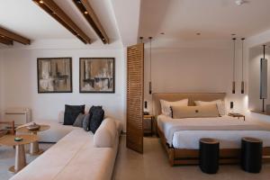 a bedroom with two beds and a couch at SantAnna Luxury Suites in Imerovigli +57 photos