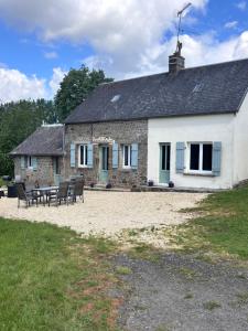 a building with a table and chairs in front of it at La Ramée - 2 bedroom - Wi-Fi - Garden - Parking in Saint-Siméon